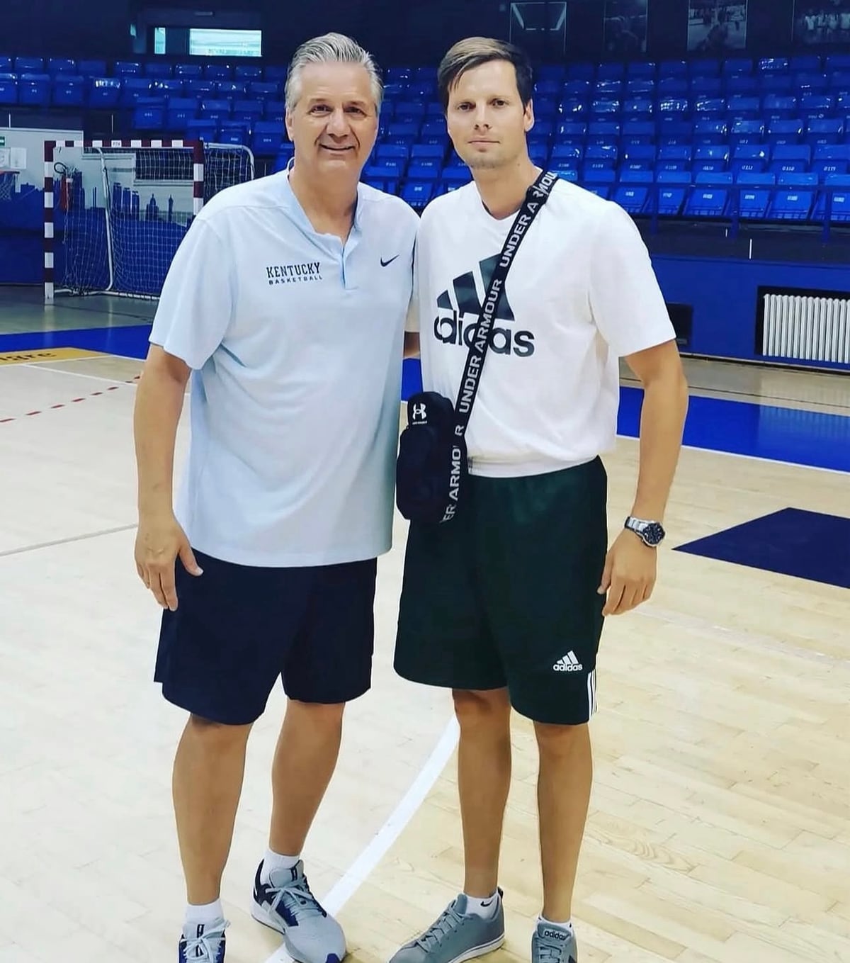 Coach Stefan Stankovic with a visiting coach in a basketball arena