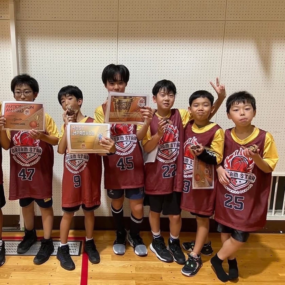 Dream Star players holding award certificates and trophies after a tournament