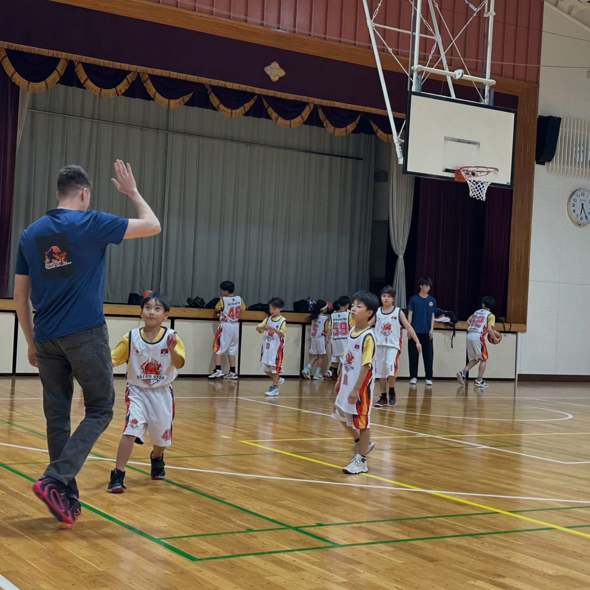 Coach Stefan Stankovic high-fiving a young player