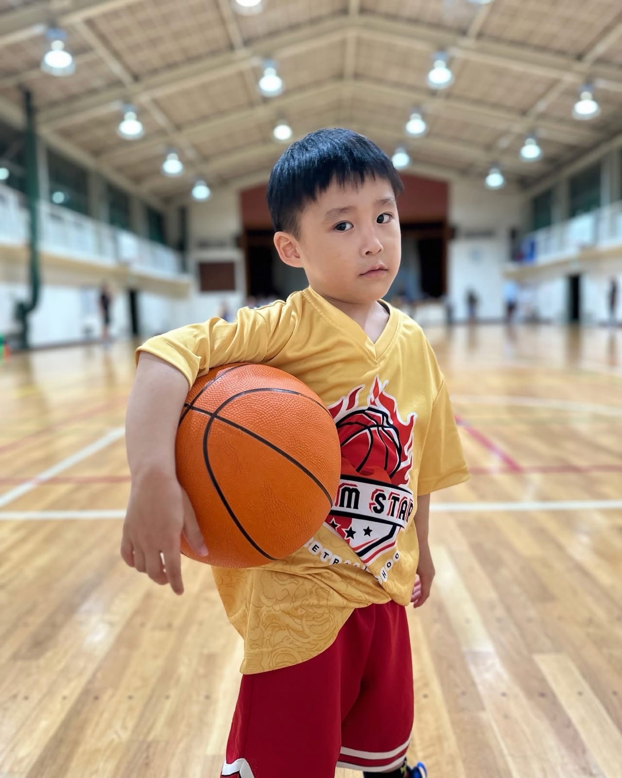 Young player holding a basketball during training